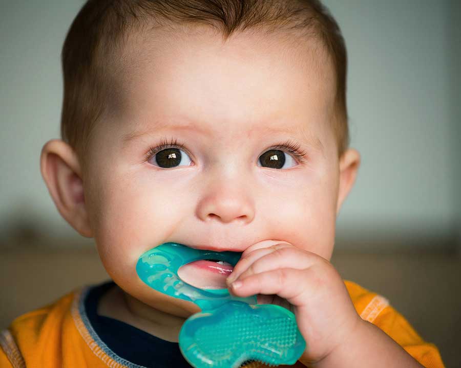Baby infant chewing on a teething ring