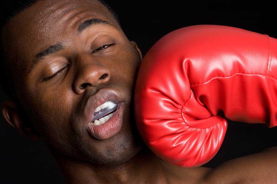 Man gets hit in the face with a red boxing glove