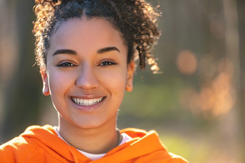 Girl smiling outside with healthy gums
